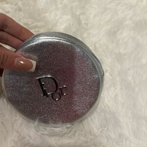 Dior Beauty silver round makeup pouch.